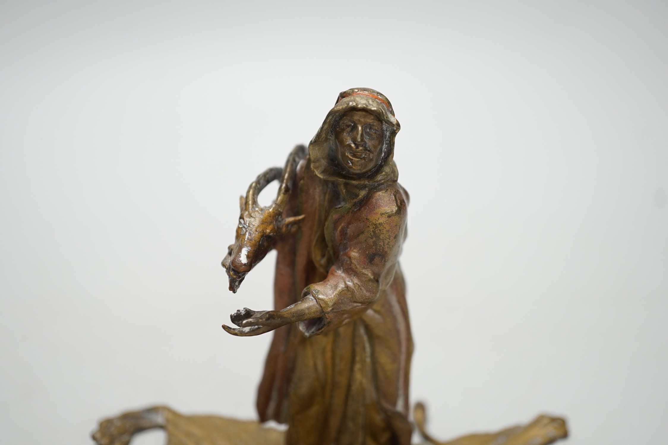 An Austrian cold painted bronze model of a Bedouin trader, depicted holding an Ibex head, standing on a lion skin, after Franz Bergman. 12cm tall